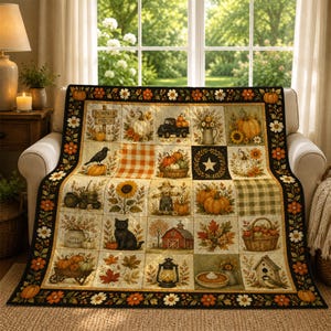 May include: A rectangular quilt featuring a grid of autumn-themed illustrations including pumpkins, a black cat, a scarecrow, a red barn, sunflowers, and a lantern. The border is decorated with a repeating pattern of orange and white flowers.