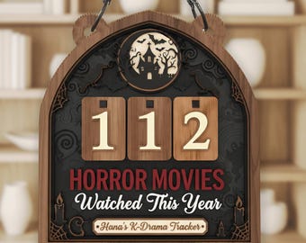 May include: Wooden Halloween-themed sign with the text "HORROR MOVIES Watched This Year" and the number "112". The sign features a haunted house, bats, and candles. Includes "Hana's K-Drama Tracker".