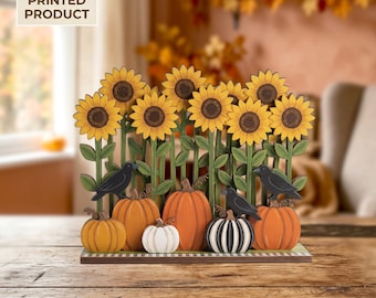 May include: A 2D flat printed decorative display featuring a row of yellow sunflowers on green stems, orange and white pumpkins, and black crows. The base is rectangular with a checkered pattern. Text on the image reads 2D FLAT PRINTED PRODUCT.