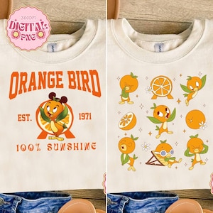 May include: Cream-colored sweatshirt featuring the text "ORANGE BIRD" in orange, with a cartoon orange bird character. The design includes the text "EST. 1971" and "100% SUNSHINE". The right side of the shirt has multiple orange bird illustrations.