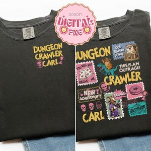 Può includere: Una t-shirt grigio antracite con una piccola stampa sul petto che recita Dungeon Crawler Carl con un'icona di teschio e trofeo. Il retro mostra una grande grafica con illustrazioni in stile francobollo di un gatto, dinosauro e capra.