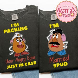 Può includere: Due magliette grigio scuro con personaggi a forma di testa di patata dei cartoni animati. Una maglietta dice "I'M PACKING Your Angry Eyes JUST IN CASE". L'altra dice "I'M Married SPUD". Entrambe le magliette hanno l'etichetta Comfort Colors.