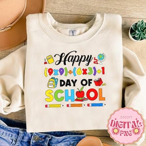 May include: Cream-colored sweatshirt with the words "Happy Day of School" in colorful letters and graphics. The design includes a globe, apple, books, and pencils. The text also includes a math equation.