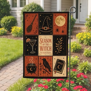 Puede incluir: Una bandera de jardín rectangular con una cuadrícula de nueve paneles en tonos naranja y negro. Las ilustraciones incluyen una escoba, un sombrero de bruja, luna llena, arañas, cóctel, rama, caldero humeante, cuervo y un libro con la etiqueta Spells. El texto dice Season of the Witch y The Smith Family.