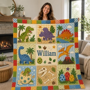 May include: A multi-colored patchwork quilt featuring various dinosaur illustrations, including a green T-Rex, a purple triceratops, a blue long-necked dinosaur, and a flying pterodactyl, with the name William printed in the center square.