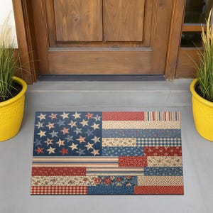 May include: A rectangular doormat featuring a patchwork design of the American flag. The mat incorporates various patterns, including stars, stripes, floral prints, and gingham, in shades of blue, red, and cream. The mat is placed on a concrete surface in front of a wooden door.