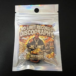 May include: A white ceramic mug with a black handle and the text "But First, Coffee" in a bold, black font. The mug is set against a blurred background, suggesting a cozy setting.