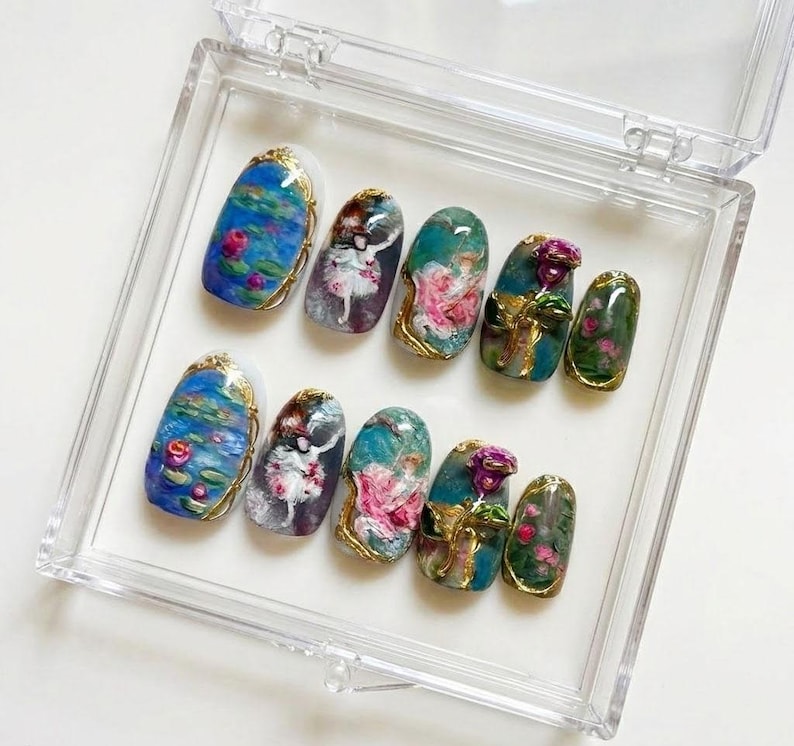 Puede incluir: Un juego de diez u&ntilde;as artificiales en una caja de pl&aacute;stico transparente. Cada u&ntilde;a presenta un dise&ntilde;o &uacute;nico, que incluye nen&uacute;fares, bailarinas y detalles florales, con ribetes dorados. Las u&ntilde;as son de forma ovalada y tienen un acabado brillante.