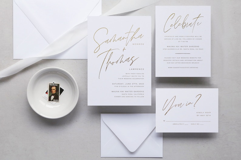 May include: Gold foil wedding invitation suite with a white background. The main invitation features the couple's names, "Samantha + Thomas", in a modern calligraphy font. The RSVP card features the text "You in?" in the same font.