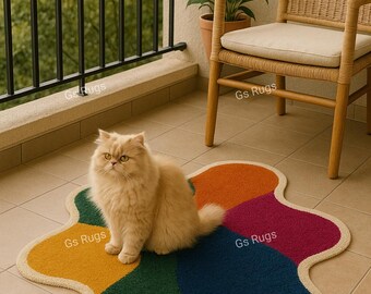 May include: A colorful, flower-shaped rug with sections of yellow, orange, green, blue, and magenta. A fluffy, light-colored cat sits on the rug. A woven chair and a balcony with a black railing are in the background.