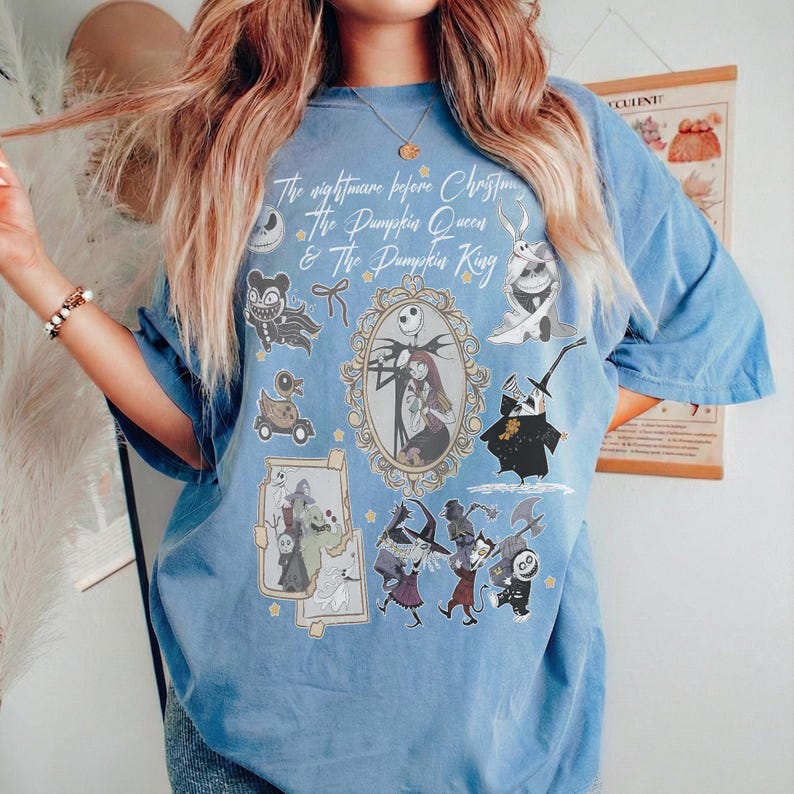 Pu&ograve; includere: Una maglietta azzurra con personaggi di "Nightmare Before Christmas". La maglietta presenta una grande grafica con Jack e Sally in una cornice decorativa, circondata da altri personaggi e il testo "The Nightmare Before Christmas & The Pumpkin Queen & The Pumpkin King."