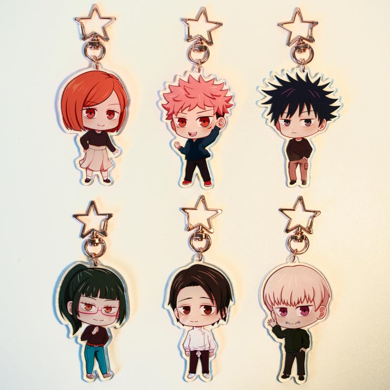 May include: Six anime-style character keyrings are displayed. Each keyring features a different character with distinct hair and clothing, attached to a star-shaped charm and a metal ring. The characters are in various poses.