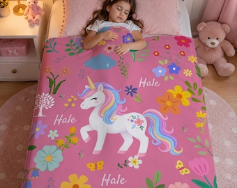 May include: A pink fleece blanket featuring a white unicorn with a rainbow mane and tail, surrounded by colorful flowers, butterflies, and green foliage. The name Hale is printed in white script in three locations across the fabric surface.