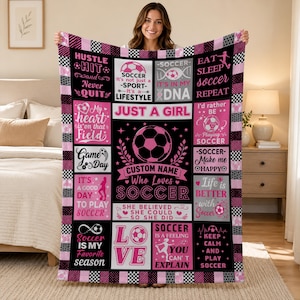 May include: A black, white, and pink fleece blanket featuring a collage of soccer-themed graphics and text, including phrases like "Just a girl who loves soccer," "Eat sleep soccer repeat," and "Soccer is in my DNA," with a checkered border.