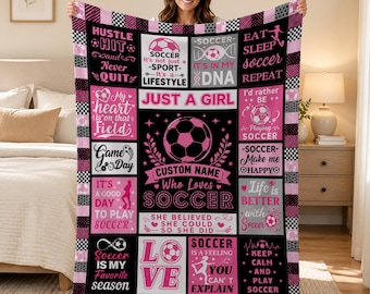 Può includere: Una coperta in pile nera, bianca e rosa con un collage di grafiche e testi a tema calcio, incluse frasi come "Just a girl who loves soccer", "Eat sleep soccer repeat" e "Soccer is in my DNA", con un bordo a scacchi.
