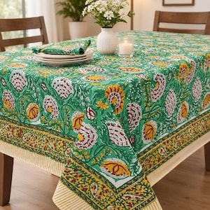 May include: A rectangular tablecloth featuring a vibrant green base with a repeating floral pattern in shades of yellow, white, and deep red. The border displays a yellow and green paisley design with a striped yellow and white edge finish.
