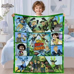May include: A colorful Wild Kratts blanket featuring various characters and creatures from the animated series. The blanket has a green border and a central design with the show's title. The design includes images of animals and the show's characters.