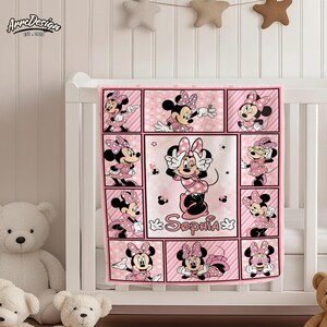 May include: Pink baby blanket featuring Minnie Mouse in various poses. The blanket has a grid design with Minnie Mouse images in each square, along with the name "Sophia". The blanket is decorated with pink polka dots and stripes.