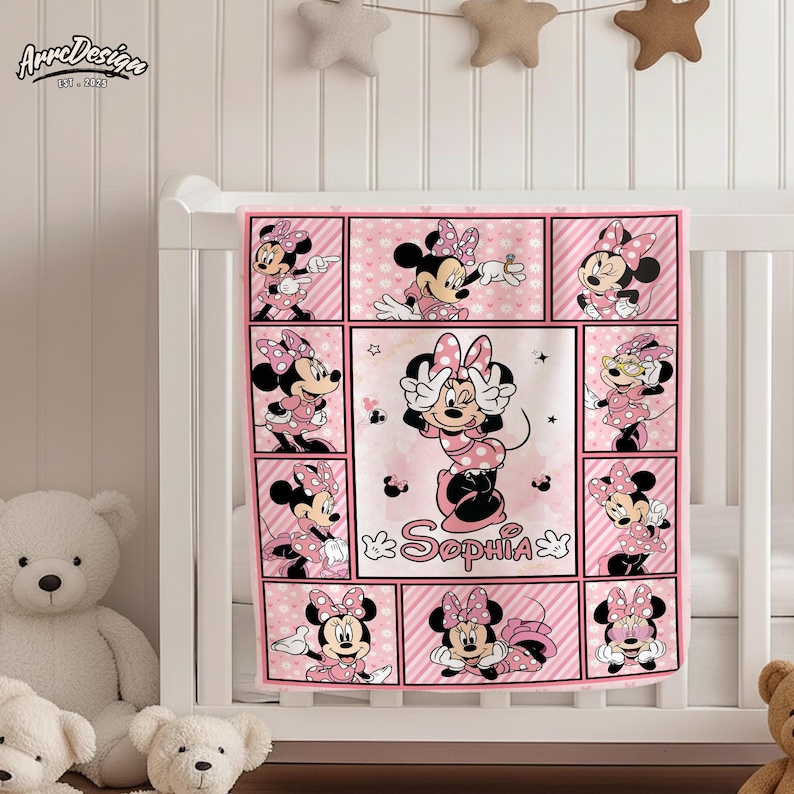 May include: Pink baby blanket featuring Minnie Mouse in various poses. The blanket has a grid design with Minnie Mouse images in each square, along with the name "Sophia". The blanket is decorated with pink polka dots and stripes.