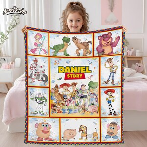 May include: A colorful blanket featuring characters from the "Toy Story" movie, including Woody, Buzz Lightyear, and others. The blanket has a personalized name "DANIEL" and "STORY" text. The border is red, blue, and yellow.
