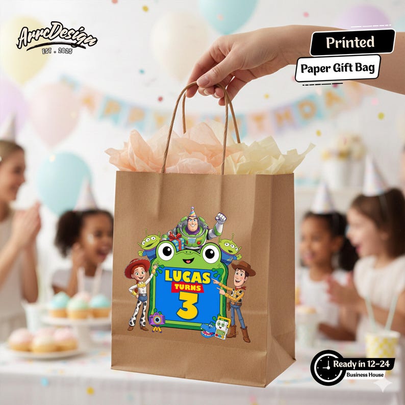 May include: A brown paper gift bag featuring a colorful graphic of Toy Story characters including Buzz Lightyear, Woody, Jessie, and green aliens surrounding a green frog shape with the text Lucas Turns 3. The bag has brown paper handles.