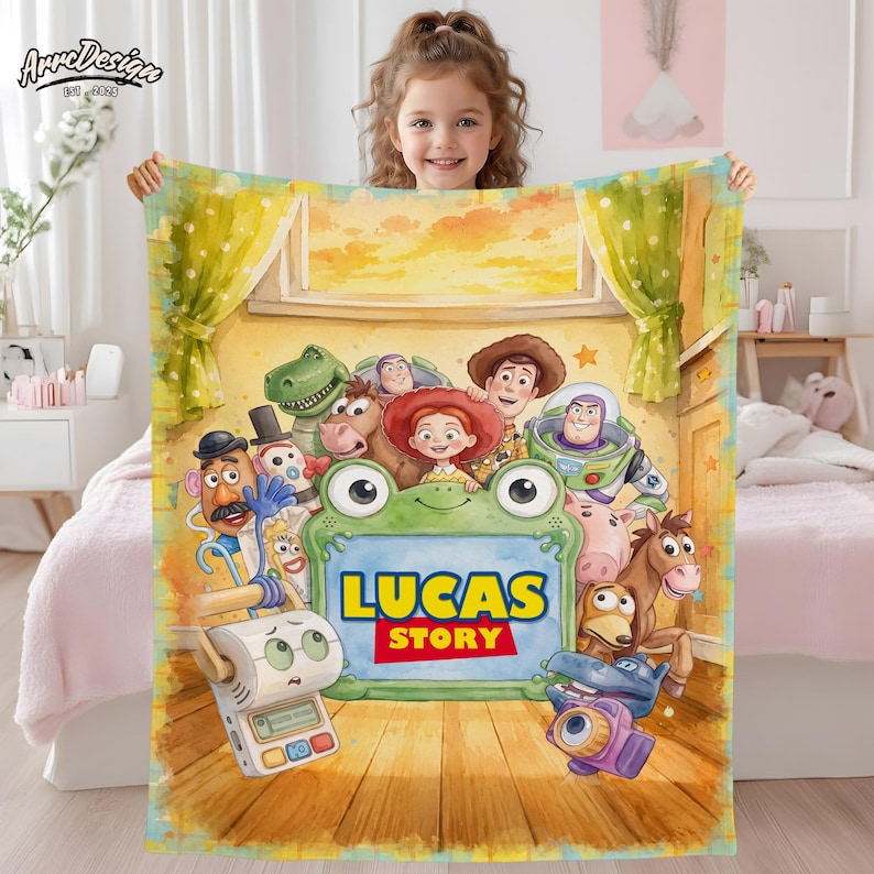 May include: A rectangular fleece blanket featuring a colorful illustration of various animated toy characters surrounding a large green frog-shaped frame with the text LUCAS STORY printed in bold yellow and red letters on a wooden floor background.