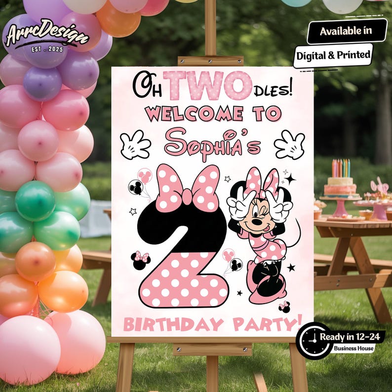 May include: A pink and black birthday party sign featuring Minnie Mouse, the number 2, and the text "Oh Twodles! Welcome to Sophia's Birthday Party!" The sign is on an easel with balloons in the background.