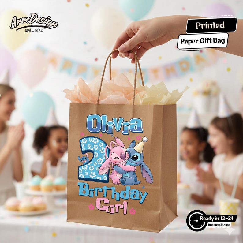 May include: A brown paper gift bag with the name "Olivia" and the number "2" printed on it. The bag features a cartoon illustration of two characters hugging, with the words "Birthday Girl" below. The bag is filled with tissue paper.