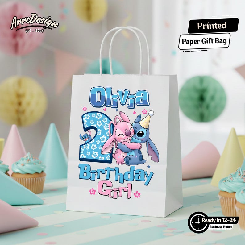 May include: White paper gift bag with the text "Olivia" and "2 Birthday Girl" in blue and pink. Features a cartoon illustration of Stitch and Angel hugging. Includes the text "Printed Paper Gift Bag".
