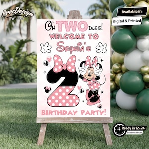 May include: A pink and white birthday party sign featuring Minnie Mouse. The sign says "Oh Twodles! Welcome to Sophia's Birthday Party!" and includes the number 2 with a polka dot bow. The sign is on a wooden easel.