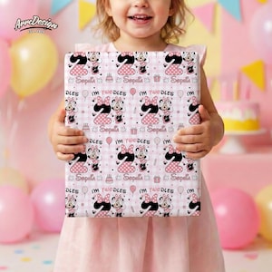 Może przedstawiać: Zapakowany prezent z różowo-białym wzorem przedstawiającym Minnie Mouse, cyfrę 2 oraz tekst "Sophia" i "I'm Twoodles". Prezent trzyma małe dziecko, na różowym tle i balonach.