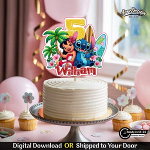 May include: A white frosted cake with a decorative topper featuring Lilo and Stitch, palm trees, and a surfboard. The topper has the number 5 and the name "William". The cake is on a silver cake stand, surrounded by cupcakes and balloons.