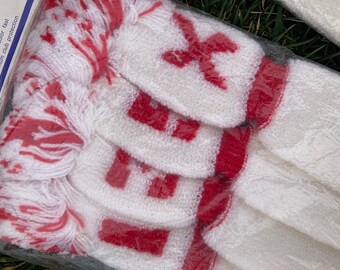 May include: White golf club head covers with red trim and a red "X" logo. The covers are made of a soft, fuzzy material and are designed to protect golf clubs from damage.