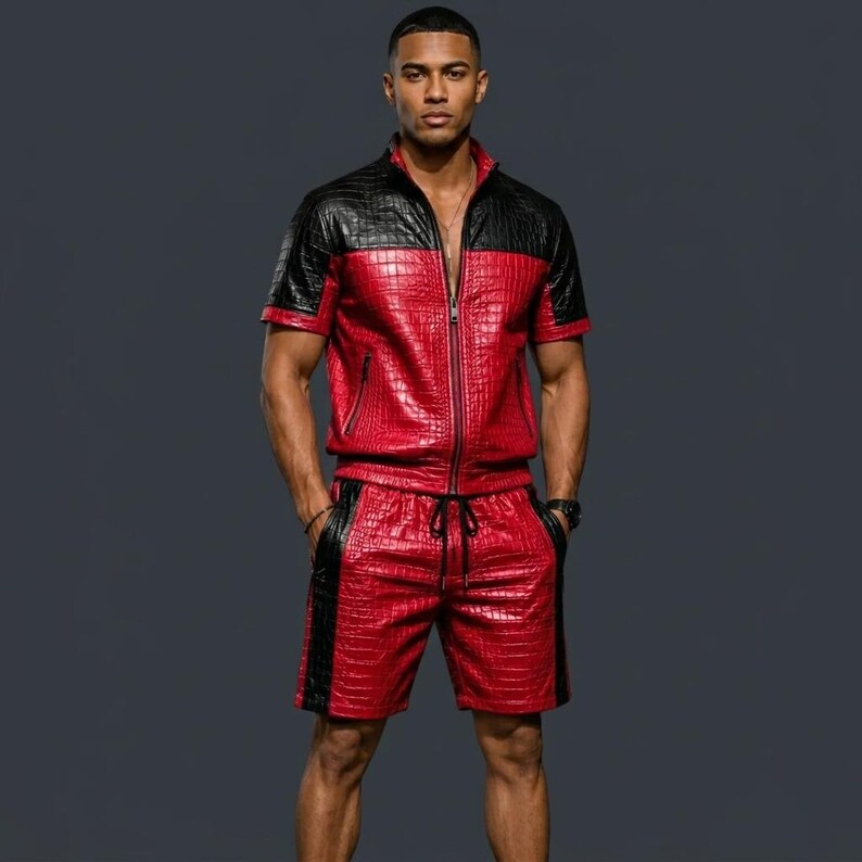 May include: A two-piece set consisting of a short-sleeved, full-zip jacket and matching shorts. The garment features a red and black crocodile-embossed texture, with black panels on the shoulders and down the sides of the shorts.
