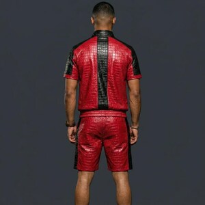 May include: A short-sleeved shirt and shorts set featuring a red and black crocodile skin texture pattern. The shirt has a central black vertical panel and black side panels, while the shorts feature matching black side panels along the legs.
