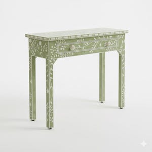 May include: A sage green console table with a single drawer. The table features white floral and leaf inlay designs on the top, drawer, and legs. The drawer has a floral knob. The table is approximately 91 cm long, 30 cm wide, and 76 cm tall.
