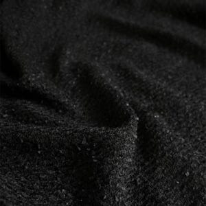 May include: Close-up of a textured black fabric with a slightly uneven surface. The fabric has a subtle sheen and a dense, woven appearance. The dark color and texture suggest a material suitable for clothing or upholstery.