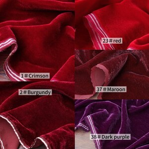 May include: A selection of velvet fabric swatches in shades of red and purple. The colours are labelled as Crimson, Burgundy, Red, Maroon, and Dark Purple. Each swatch has a white border.