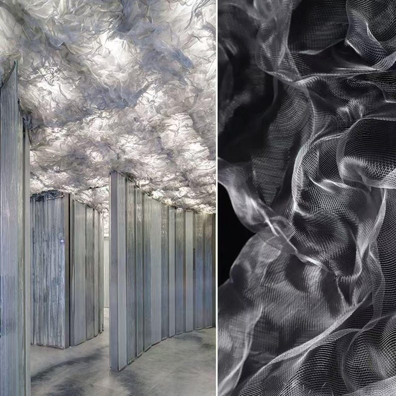 May include: An architectural interior featuring a curved hallway with vertical, gray panels. The ceiling is adorned with a cloud-like, textured material, illuminated to create a soft, diffused light. A close-up shows the delicate, layered texture.