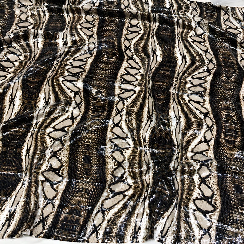 May include: Close-up of a fabric with a snakeskin pattern. The fabric has vertical stripes in shades of brown, tan, and black, creating a textured and detailed design. The pattern mimics the scales and markings of a snake.