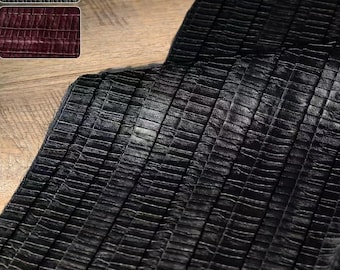 Puede incluir: Primer plano de una tela negra texturizada con un patrón de rejilla. La tela parece ser cuero o un material similar al cuero. Dos muestras de tela más pequeñas están en la esquina superior izquierda, una gris y otra burdeos.