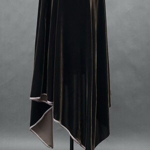 May include: A dark brown velvet fabric draped over a stand. The fabric has a soft, lustrous appearance with a contrasting light-colored trim along the edges. The background is a solid gray.