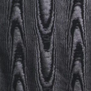 Puede incluir: Primer plano de un patr&oacute;n de vetas de madera gris oscuro. La veta de la madera tiene una orientaci&oacute;n vertical con formas org&aacute;nicas onduladas y l&iacute;neas finas y paralelas. El efecto general es una apariencia texturizada y natural.