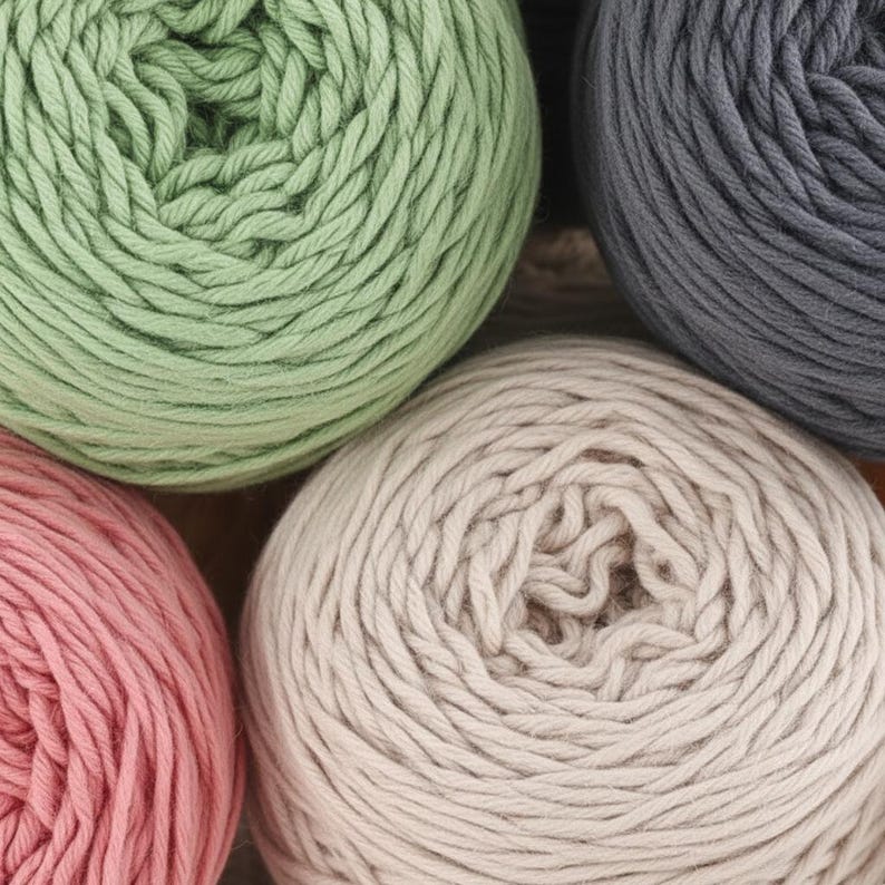 K&ouml;nnte beinhalten: Nahaufnahme von mehreren Wollkn&auml;ueln in verschiedenen Farben. Die Farben umfassen Hellgr&uuml;n, Grau, Rosa und Beige. Das Garn ist fest gewickelt, und die Textur des Garns ist sichtbar. Das Bild ist gut beleuchtet und die Farben sind lebendig. Das Garn ist wahrscheinlich f&uuml;r Strick- oder H&auml;kelprojekte.