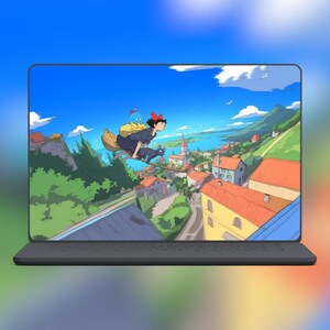 Pode incluir: Um laptop exibe uma cena de anime vibrante de uma bruxa voando em uma vassoura com um gato preto sobre uma cidade costeira. A tela mostra um c&eacute;u azul brilhante, colinas verdes e edif&iacute;cios com telhados laranja. O laptop tem uma base cinza escuro.