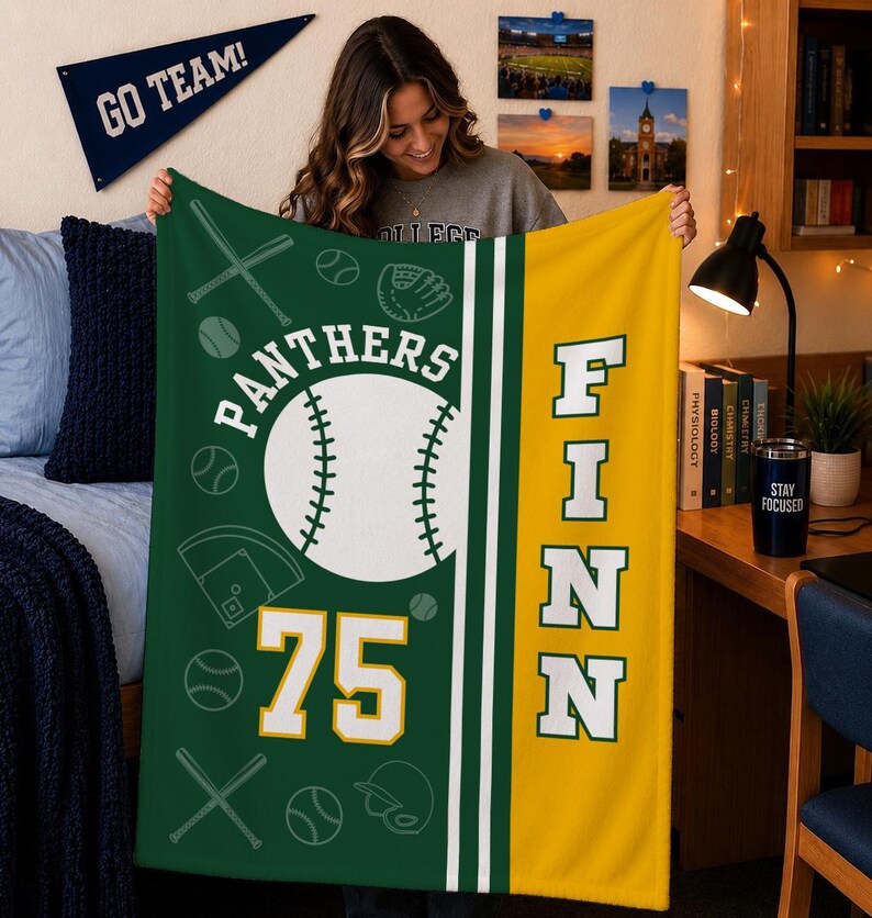 May include: A green and yellow fleece blanket featuring a large white baseball graphic, the text PANTHERS, the number 75, and the name FINN in bold white letters. The design includes scattered outlines of baseballs, bats, and a catcher's mitt.