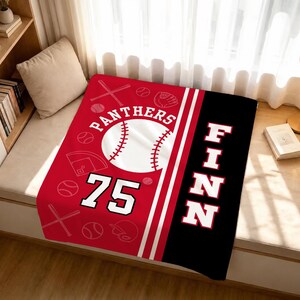 May include: A rectangular blanket featuring a red section with a white baseball graphic, the text PANTHERS, the number 75, and various baseball icons. A black vertical stripe on the right side displays the name FINN in large white capital letters.