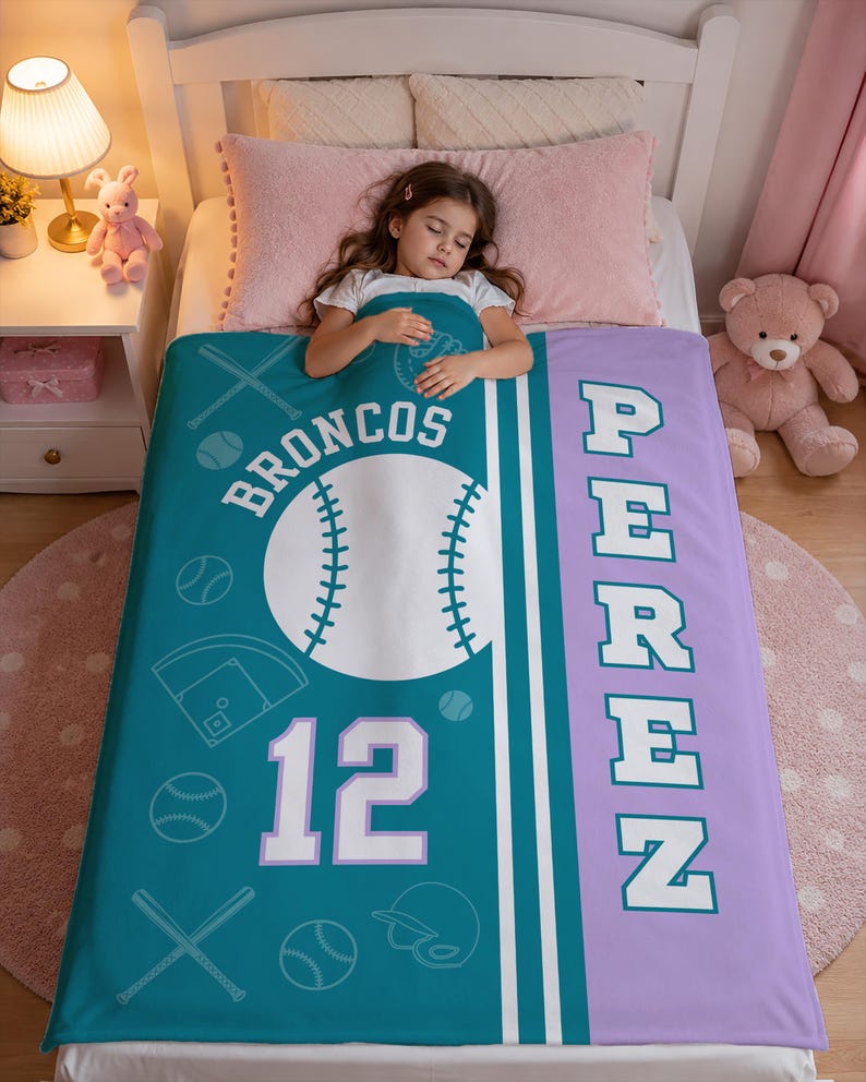 May include: A teal and lavender personalized blanket featuring a large white baseball graphic, the text BRONCOS, the number 12, and the name PEREZ in block letters. The design includes white line art of baseball bats, balls, and a catcher's mask.