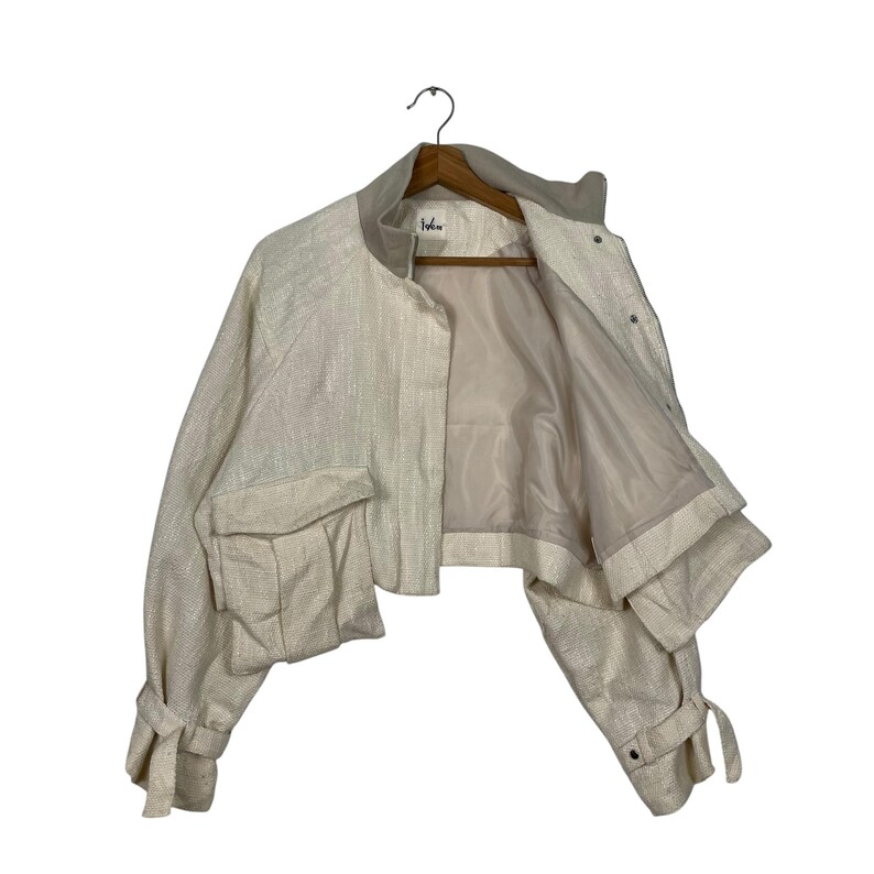 May include: A cream-colored cropped jacket with a textured weave. The jacket features a round collar, two front pockets, and tie details on the sleeves. It is hanging on a wooden hanger against a white background.