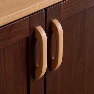 May include: Close-up of a wooden cabinet with two doors. The cabinet doors are a dark brown color, and the handles are made of light-colored wood. The top of the cabinet is a lighter shade of wood.